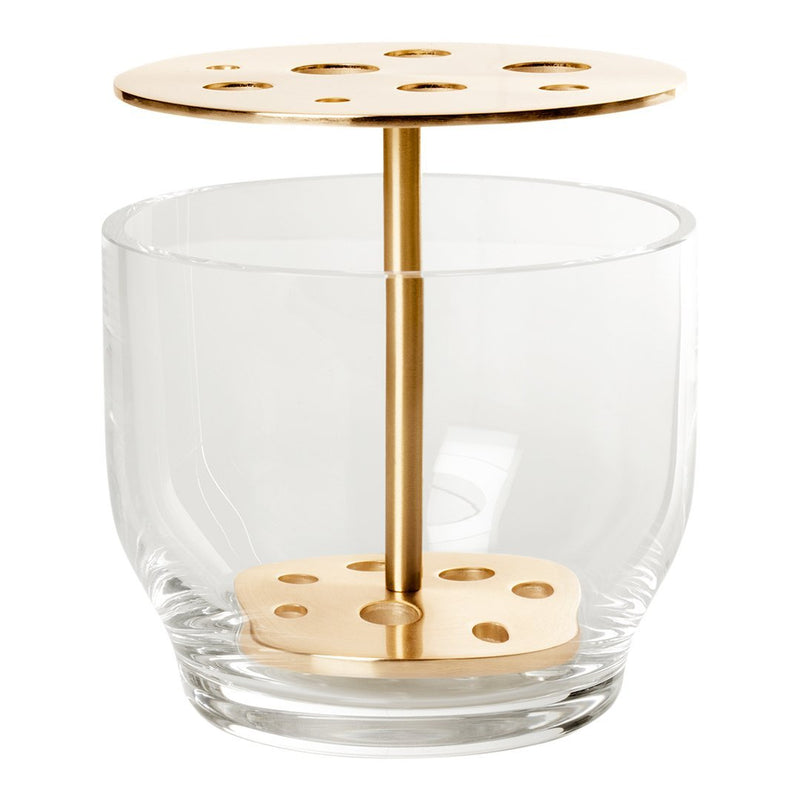Clear glass tumbler with a metallic gold holder featuring circular cutouts on top and a base design.