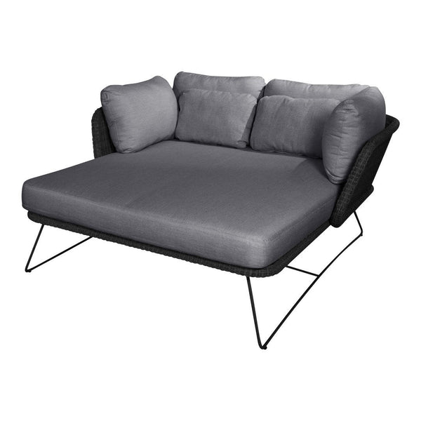 Gray upholstered outdoor sofa with black woven base and sleek metal legs, ideal for modern patio decor.