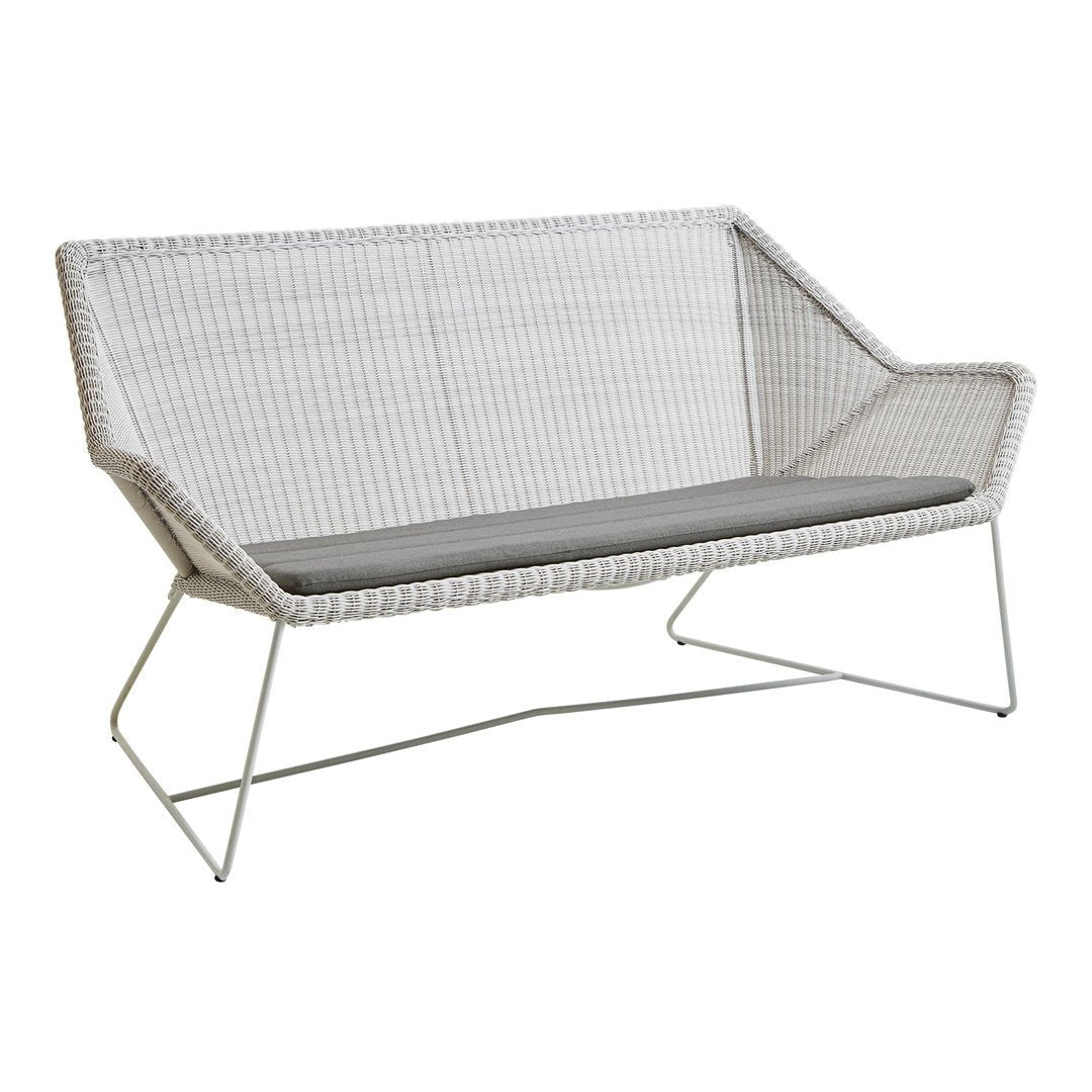 Modern white woven loveseat with a sleek gray cushion and geometric metal frame. Ideal for stylish outdoor decor.