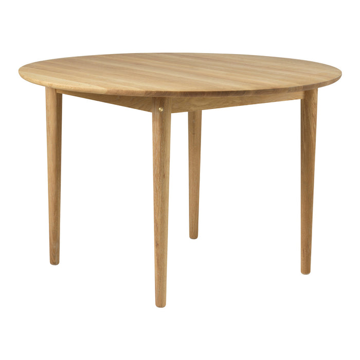 Round natural wood dining table with a smooth light oak finish and tapered legs, showcasing minimalist design.