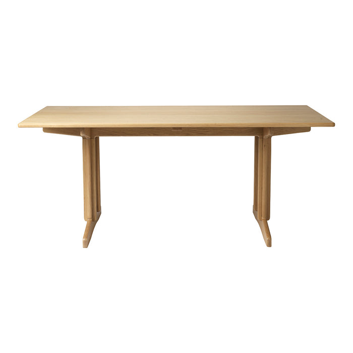 Light natural wood table with a smooth surface and minimalist design, featuring a classic rectangular shape and simple lines.