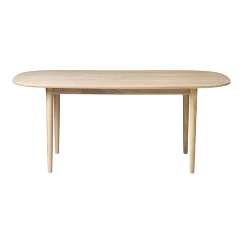 Light wood oval dining table with smooth finish and simple, modern design. Ideal for minimalist decor.