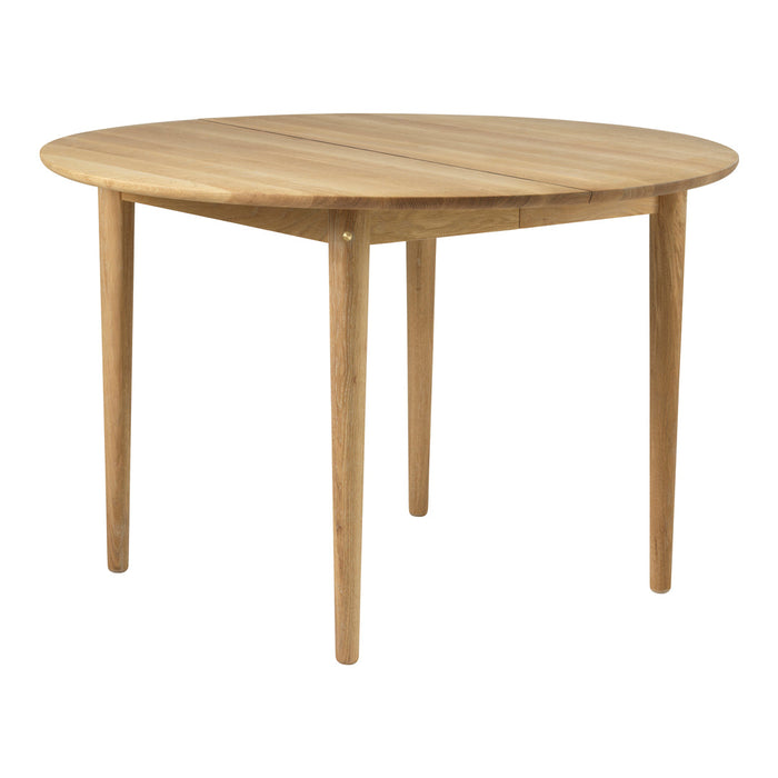 Round wooden table in natural oak finish with a smooth, solid surface and tapered legs. Ideal for modern dining spaces.
