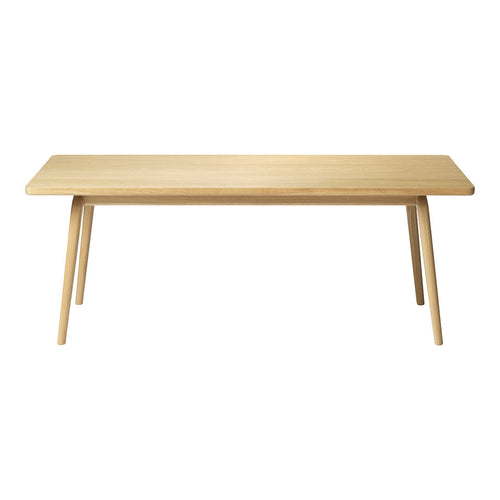 Natural wood dining table with a light beige finish and smooth, minimalist design. Ideal for modern decor.