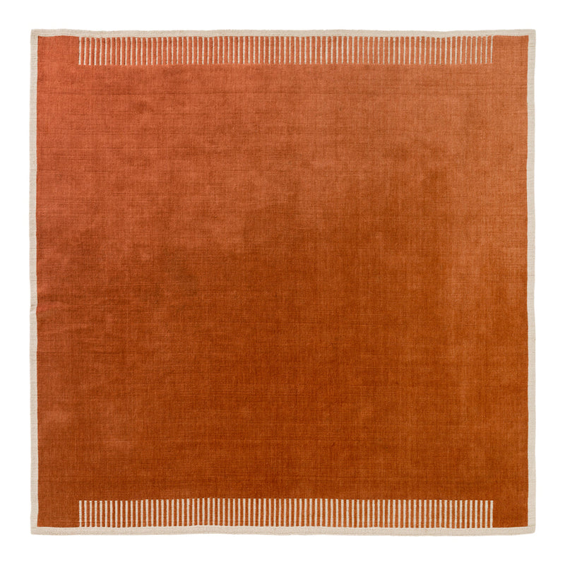 Rust-colored square rug with a subtle striped pattern along the edges.