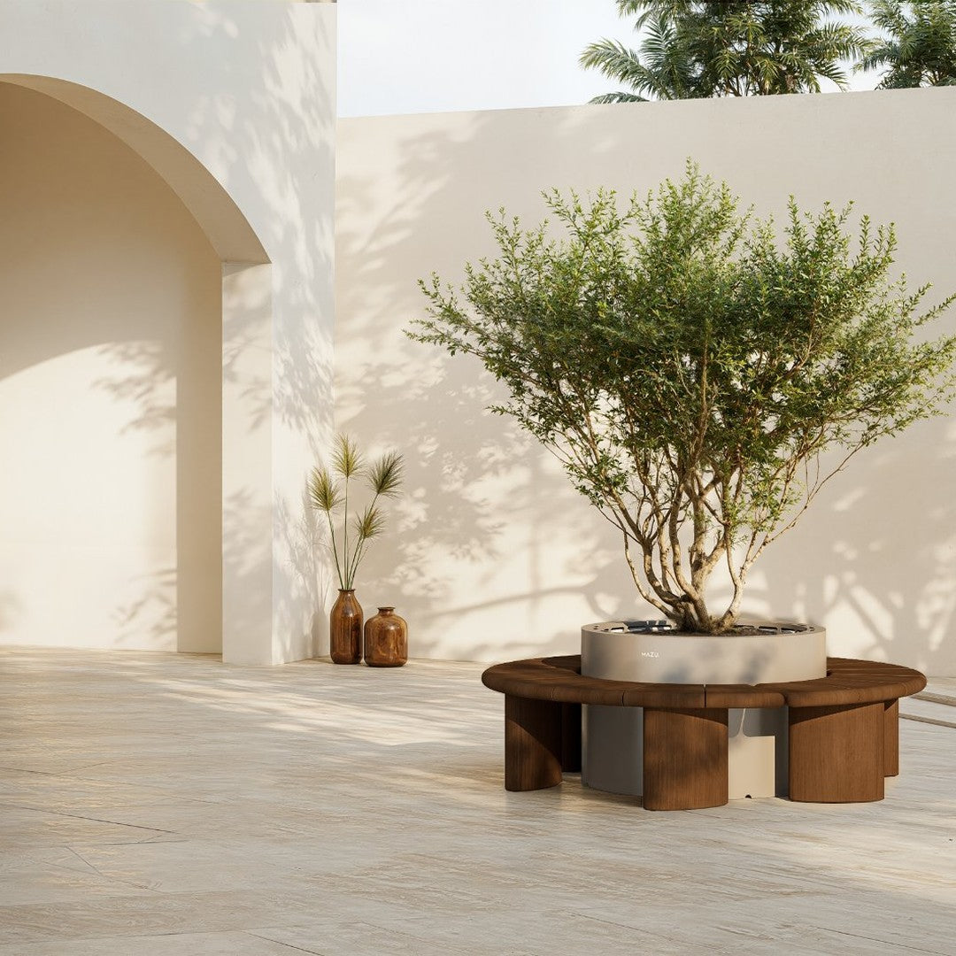 Round outdoor coffee table in dark wood with geometric pattern, surrounded by neutral-toned decor and greenery.
