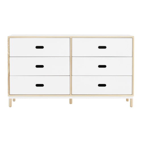 White dresser with minimalist design, featuring four drawers and contrasting black handles. Light natural wood frame.