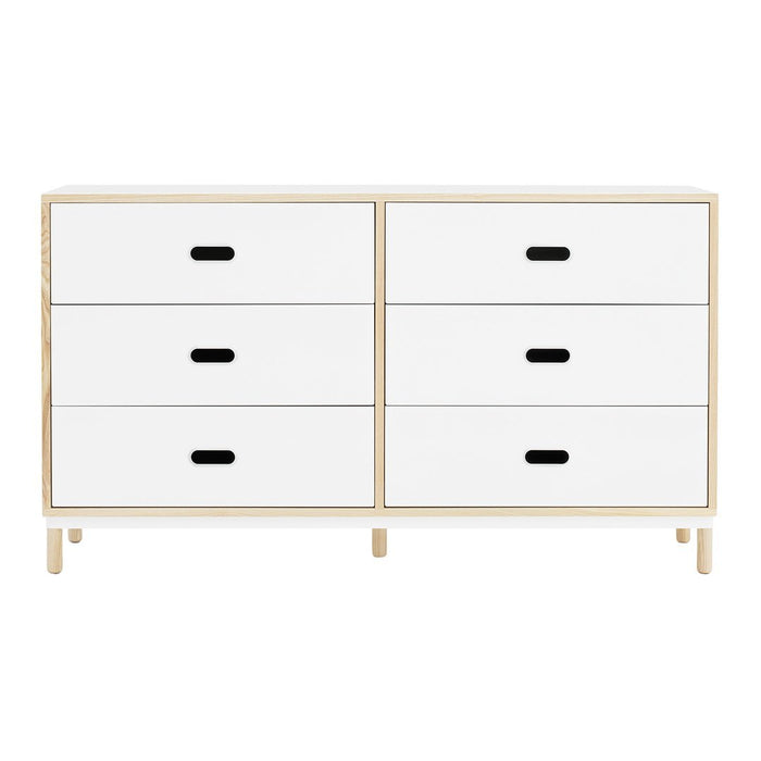 White dresser with minimalist design, featuring four drawers and contrasting black handles. Light natural wood frame.