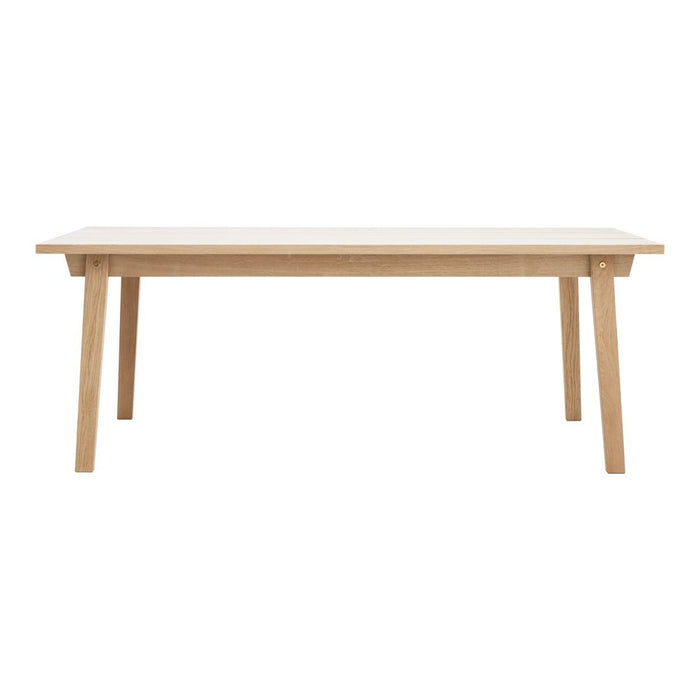 Light oak dining table with a smooth, natural wood finish and tapered legs. Simple, modern design in neutral tones.