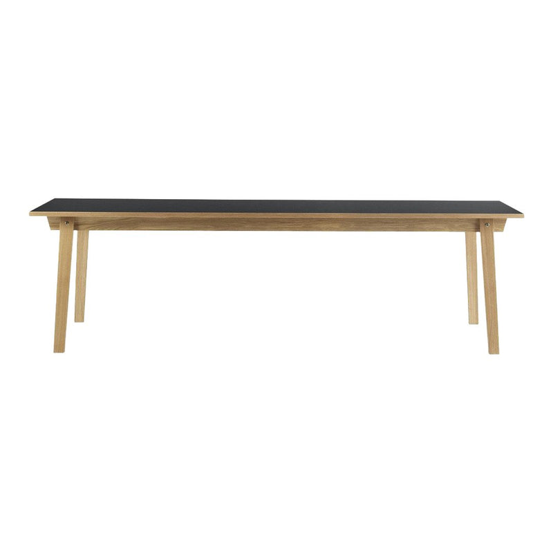 Wooden table with a sleek black top and natural wood legs, showcasing a minimalist design. Ideal for any modern space.