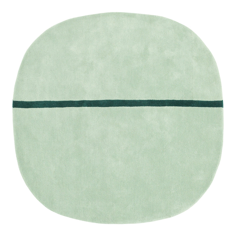 Soft mint green round rug with a contrasting dark teal line pattern across the center.