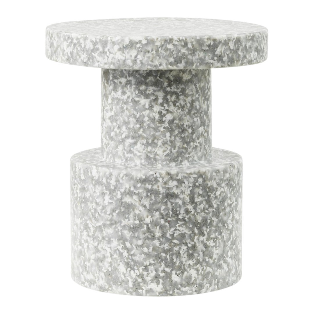 Gray speckled side table with a minimal, modern design and smooth circular top and cylindrical base.