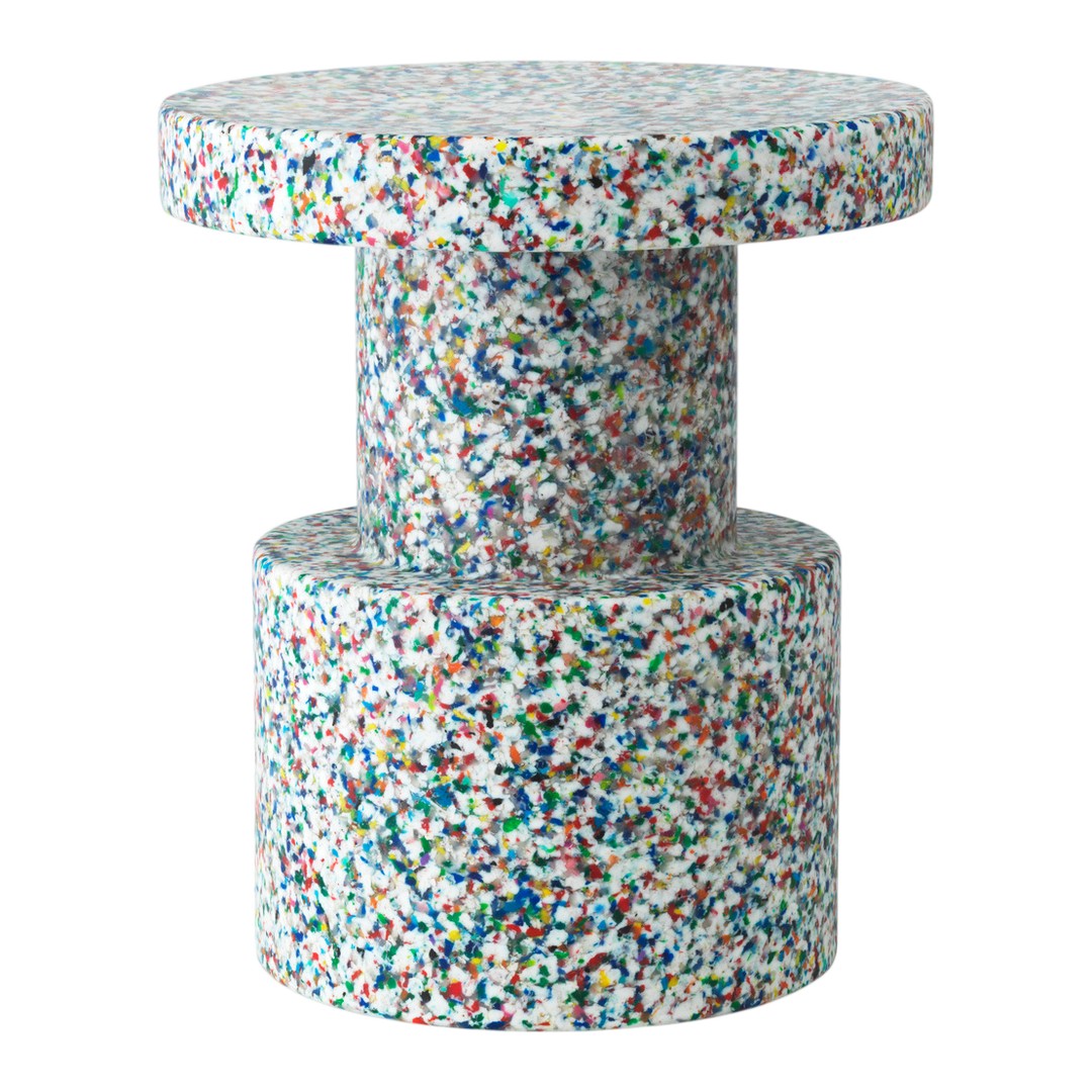 Colorful speckled table featuring a round top and cylindrical base in bright hues of blue, red, green, and white.