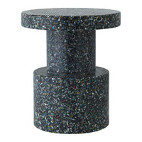 Dark speckled surface with colorful flecks, showcasing a modern, minimalist cylindrical design. Ideal for contemporary spaces.