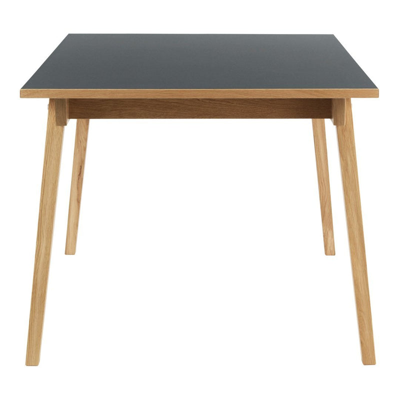 Black tabletop with natural wood legs, minimalist design, perfect for modern decor.