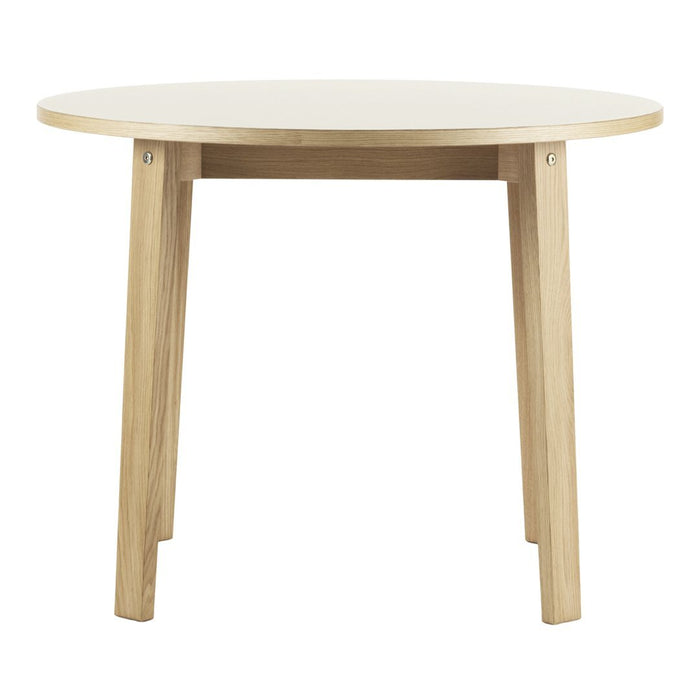 Round table with a smooth white top and natural wood legs, showcasing a minimalistic and modern design.