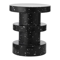 Black speckled side table with a modern, cylindrical design and smooth, glossy surface. Perfect for contemporary spaces.