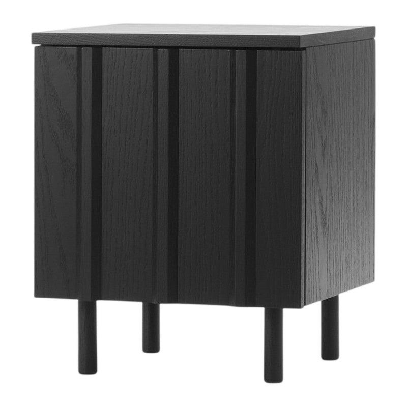 Black wooden nightstand with vertical paneling and sleek design, featuring four tapered legs.