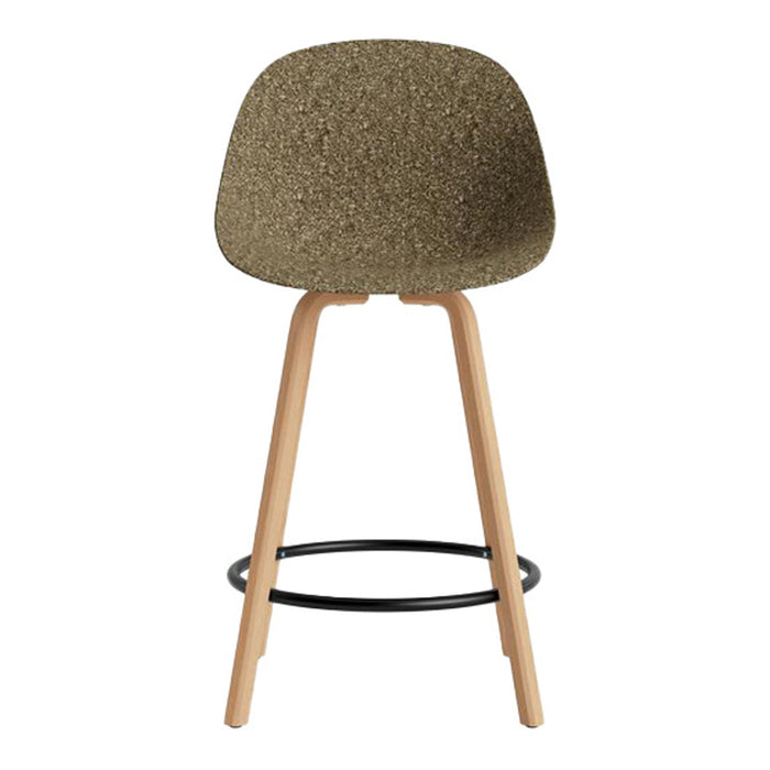 Green textured upholstery on a modern bar stool with natural wood legs and a sleek black footrest.