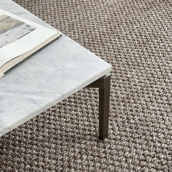 "Stylish marble tabletop in white with grey veining, paired with a textured brown woven rug."