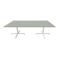 Green tabletop with a wood grain edge, supported by a sleek white metal base, minimalistic design.