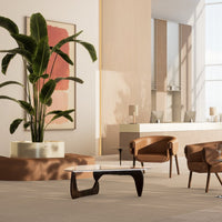 Modern living room featuring earthy tones, sleek black accents, and minimalist design with a touch of greenery.