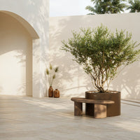 Modern brown bench and round planter against a soft beige backdrop with natural greenery and minimalist accents.
