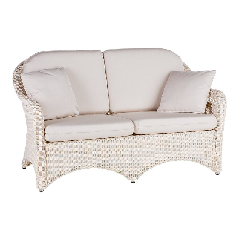 Cream-colored wicker loveseat with soft, textured fabric cushions in a neutral tone. Subtle elegance for any space.