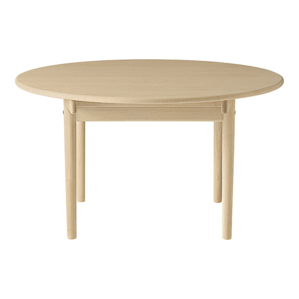 Round wooden table in a natural beige finish, featuring a smooth surface and simple, elegant design.