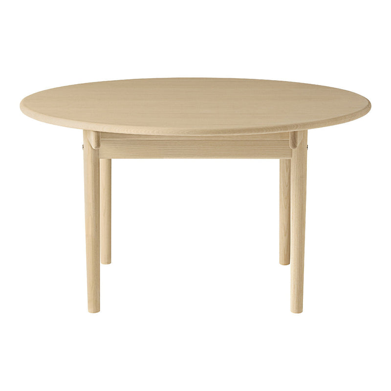 Round wooden table in a natural beige finish, featuring a smooth surface and simple, elegant design.
