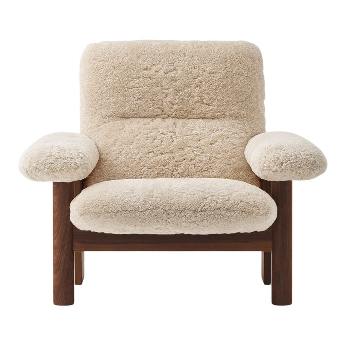 Cream-colored plush chair with a textured shearling pattern and dark wood frame. Cozy and modern design.