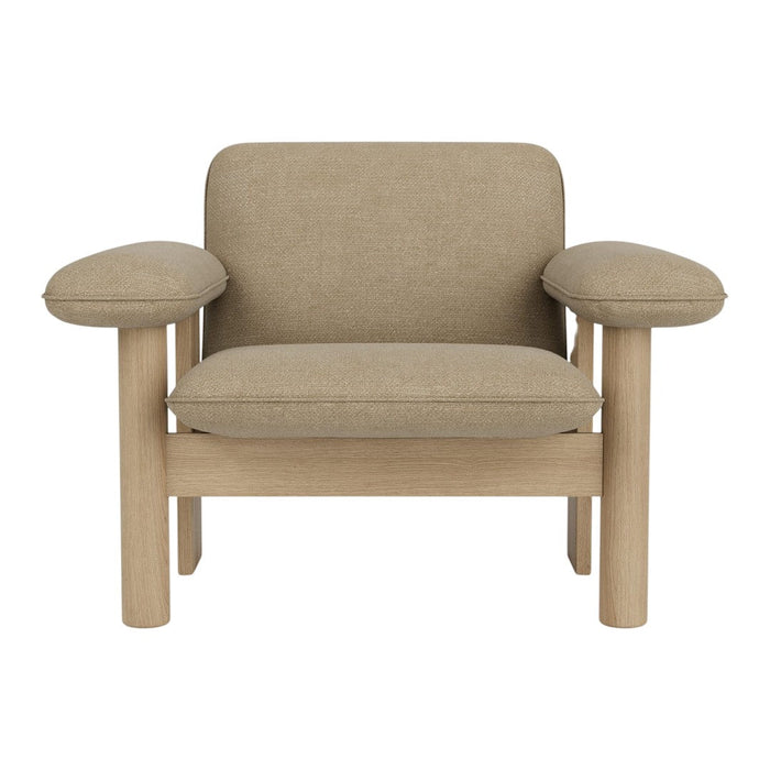 Beige upholstered armchair with soft rounded armrests and light wooden legs, featuring a minimalist design.