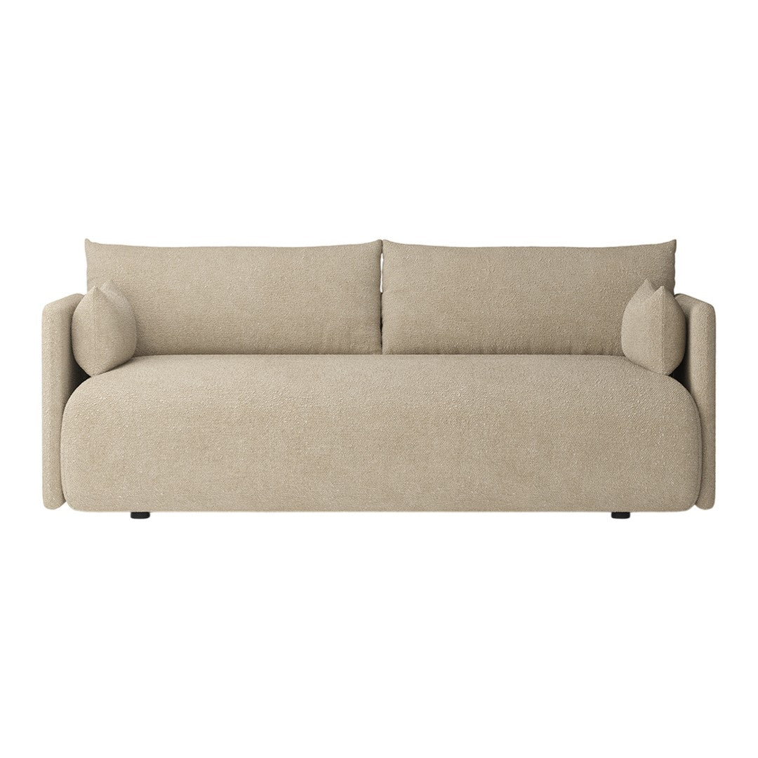 Beige upholstered sofa with smooth texture and minimalistic design, featuring round armrests and matching cushions.