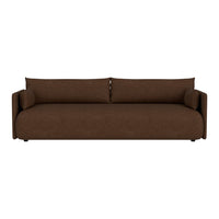 Brown sofa with a smooth texture and minimalist design, featuring two matching cylindrical pillows.