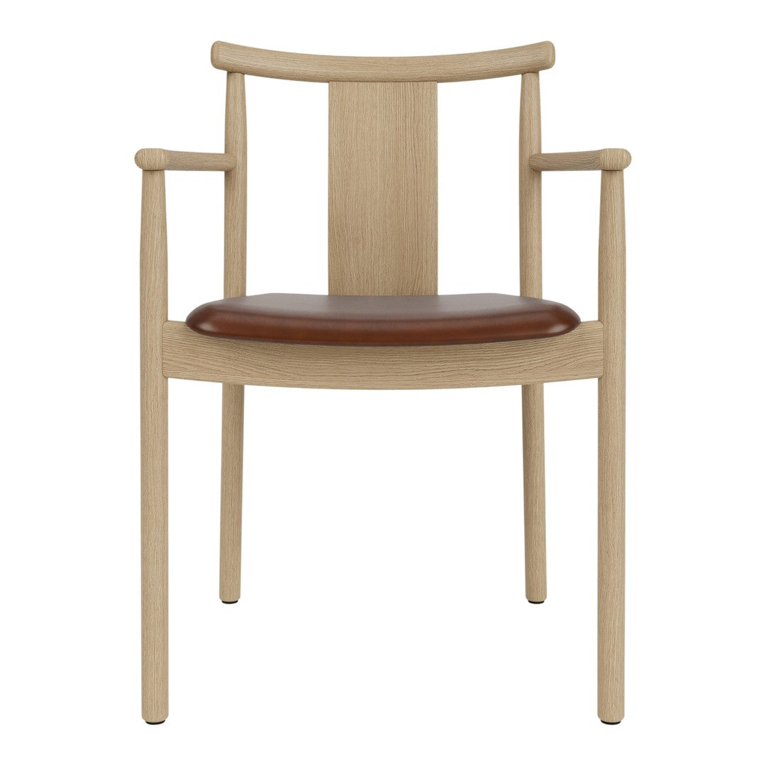 Light wood dining chair with a sleek design and a rich brown leather seat, showcasing a minimalist aesthetic.