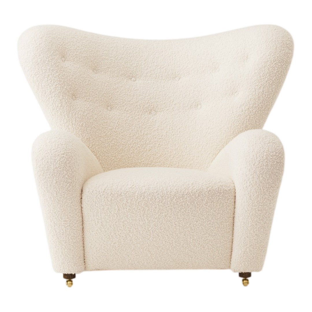 Cream-colored, textured upholstered armchair with tufted details and smooth, curved silhouette.