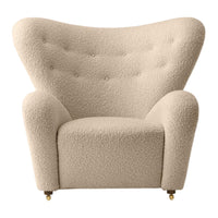 Beige upholstered armchair with textured boucle fabric and tufted buttons, featuring a stylish, curved silhouette.