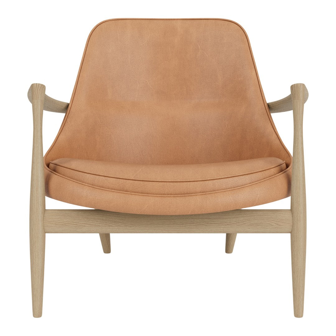 Light tan leather armchair with a smooth finish and natural wood frame, showcasing minimalist design and warm tones.