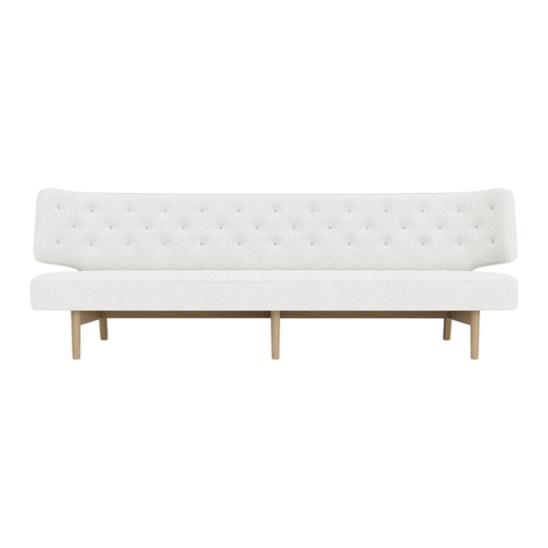White tufted sofa with a minimalistic design and light wood legs, showcasing a sleek, modern aesthetic.