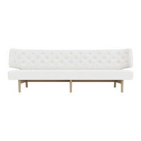 White tufted sofa with a minimalistic design and light wood legs, showcasing a sleek, modern aesthetic.