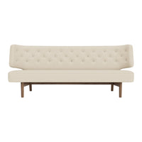 Cream-colored tufted sofa with a sleek wood base, featuring a minimalist design and elegant lines.