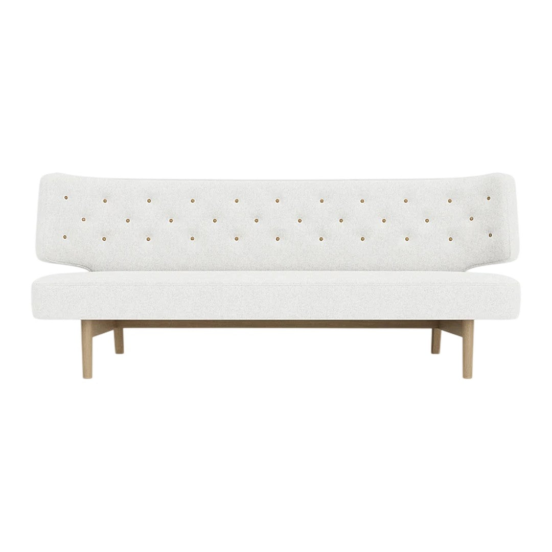 Modern white tufted sofa with subtle golden accents and natural wood legs, perfect for minimalist decor.