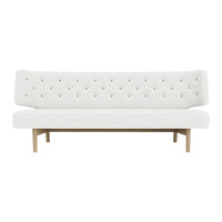 Modern white tufted sofa with subtle golden accents and natural wood legs, perfect for minimalist decor.