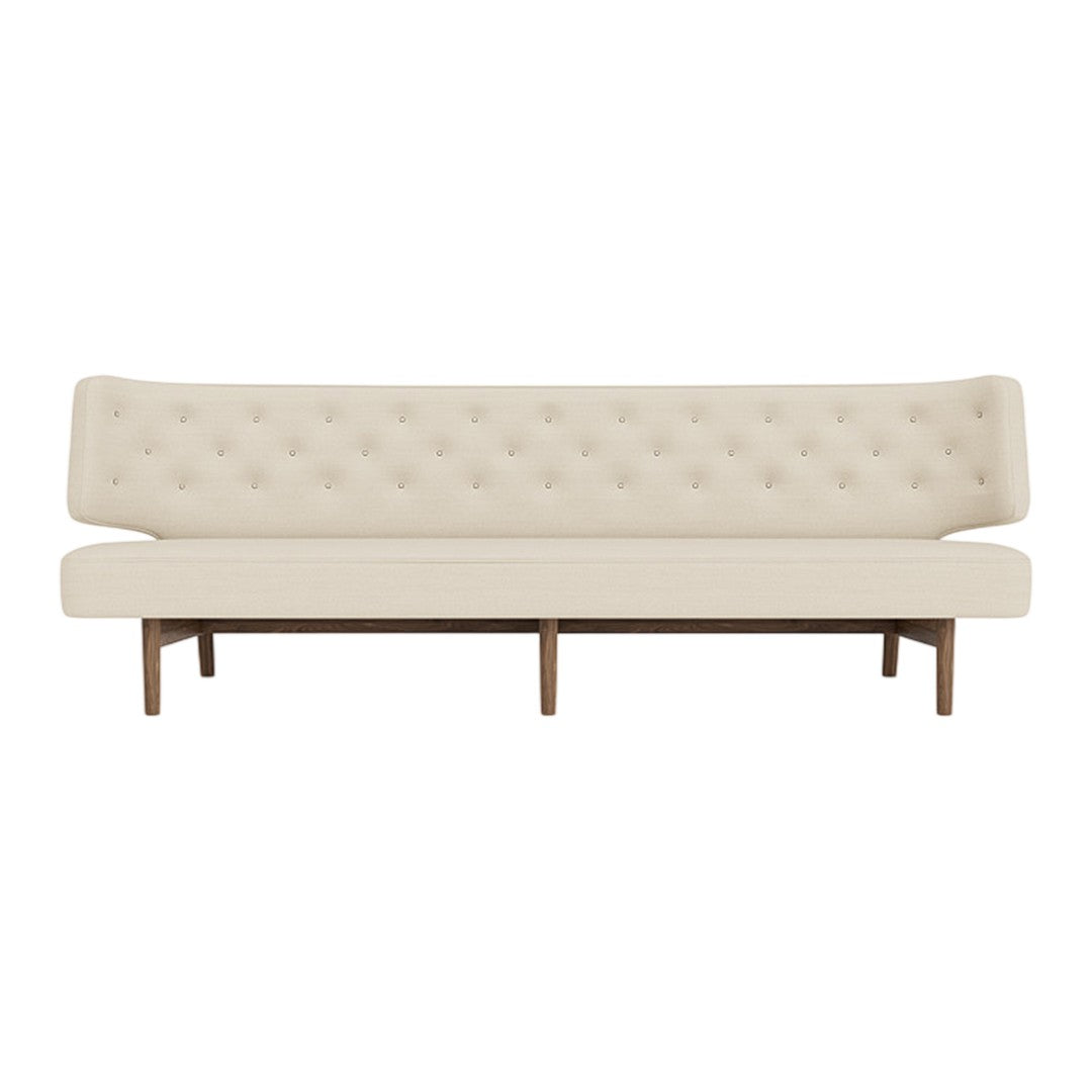 Cream upholstered sofa with tufted back and wooden legs, featuring a sleek and modern design.
