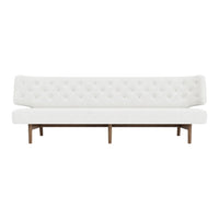 White tufted sofa with a sleek design and wooden legs, featuring a minimalist modern style.