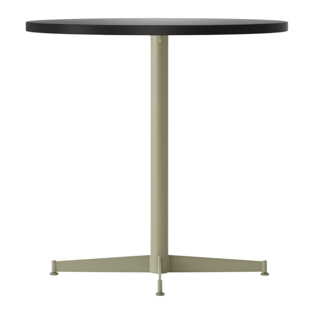 Modern round table with a black top and a light olive green metal base. Clean, minimalist design.