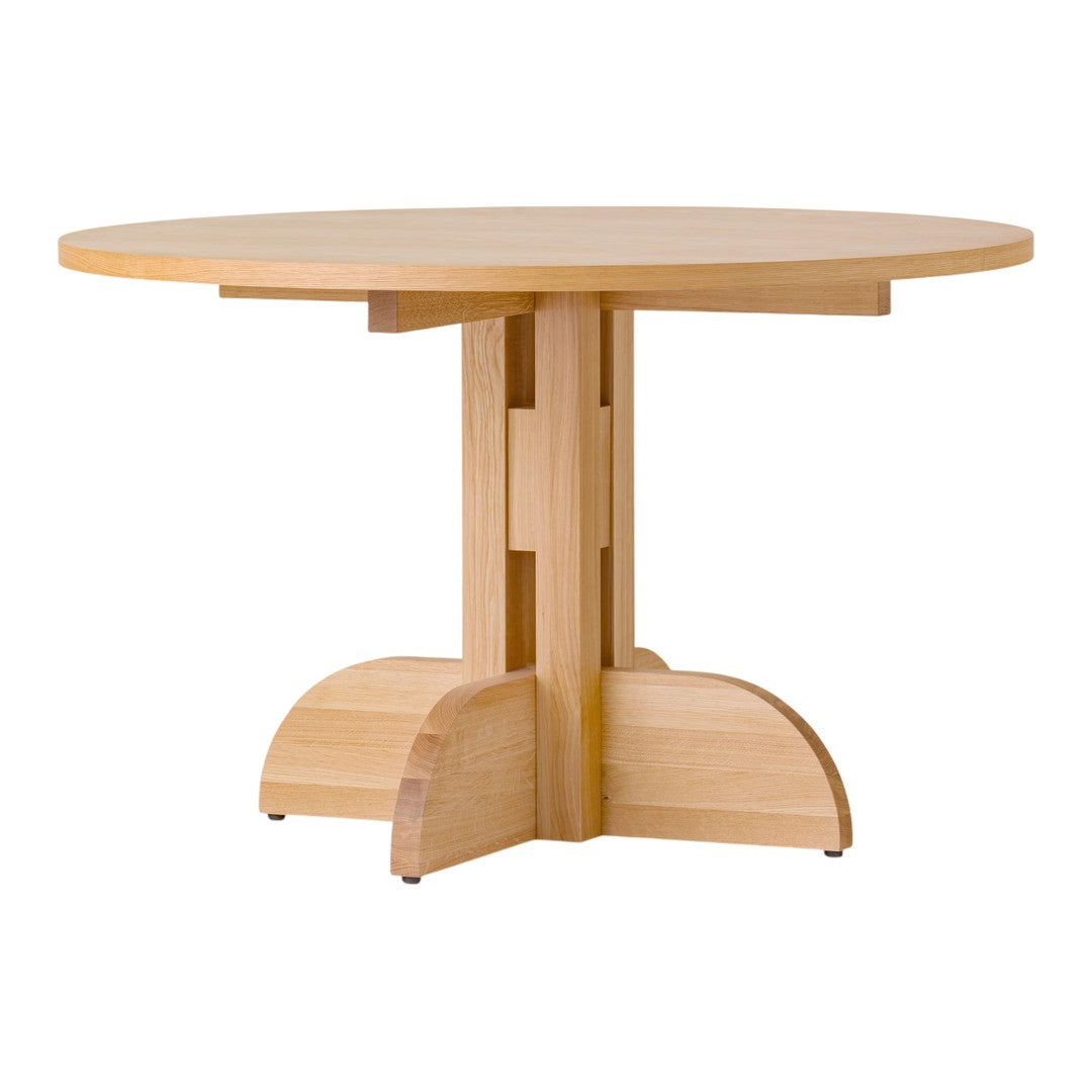 Round wooden dining table in light natural finish with a smooth surface and unique pedestal base design.