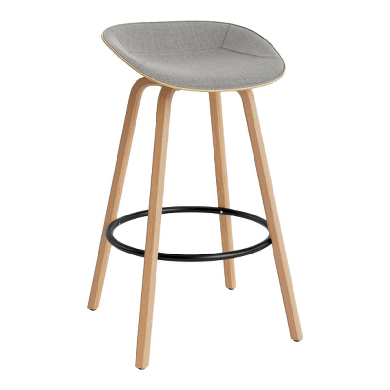 Gray upholstered bar stool with light wood legs and a black metal footrest. Sleek and modern design.