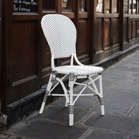 White woven chair with black stripes, featuring a classic, elegant pattern suitable for outdoor dining scenes.