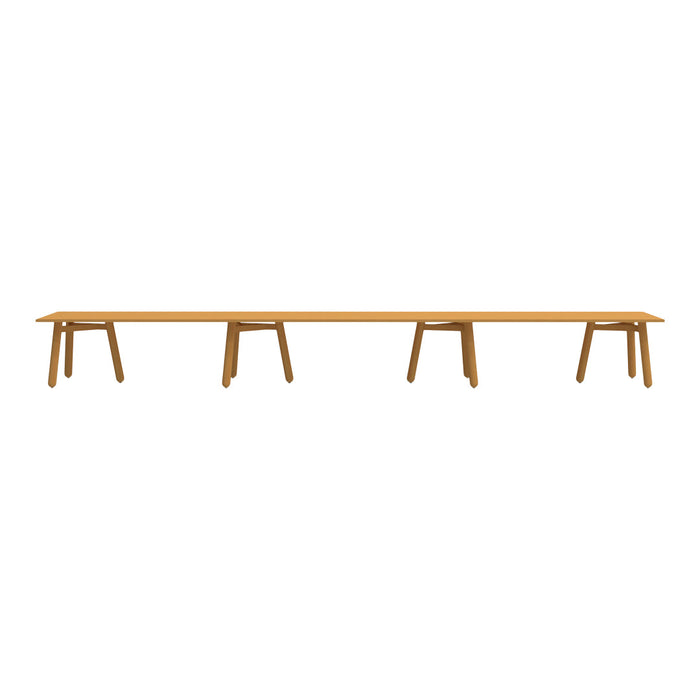 Long wooden table in warm amber color, featuring a smooth surface and simple design with three matching stools.